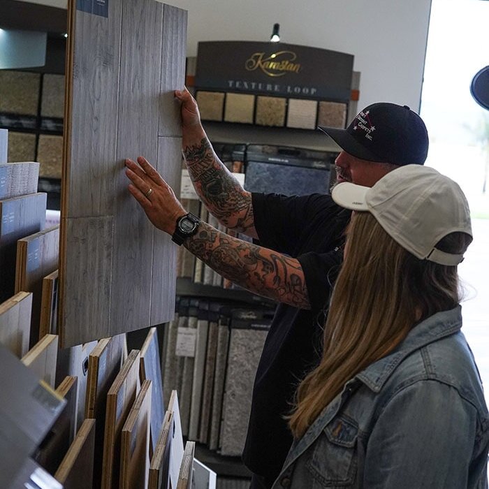 A flooring professional showcasing a products natural grain and texture at Stafford's Discount Carpets